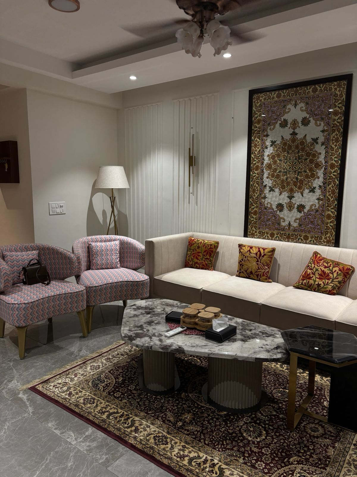 Living room corner with charcoal sofa, woven throws, and herringbone wall texture.